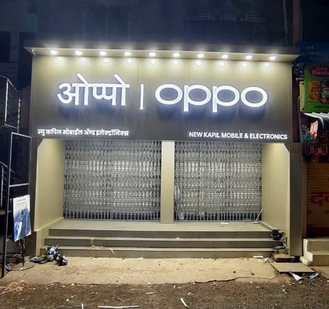 After — OPPO ACP façade with backlit channel letters at night, New Kapil Mobile & Electronics, Achalpur